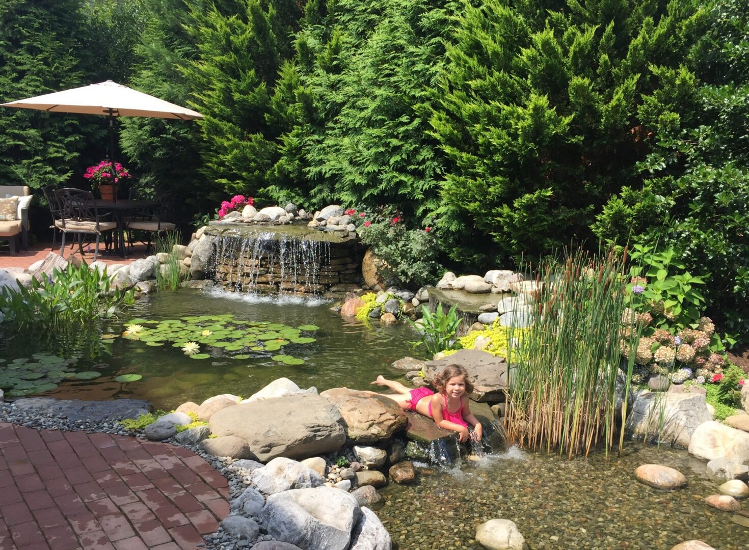 A person sitting in the water of a pond.