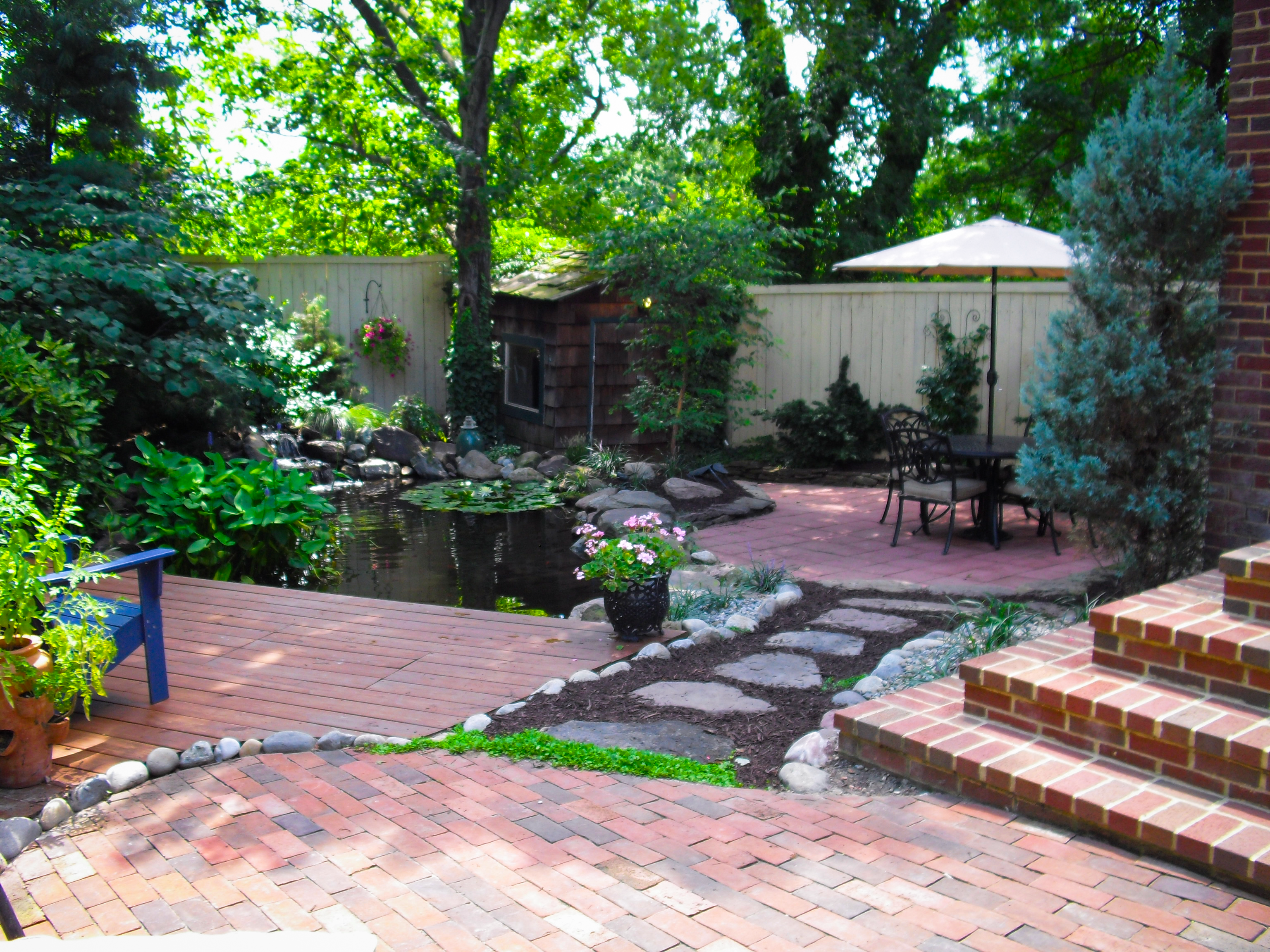A patio with brick and stone steps leading to the backyard.
