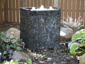 A square fountain in the middle of some rocks